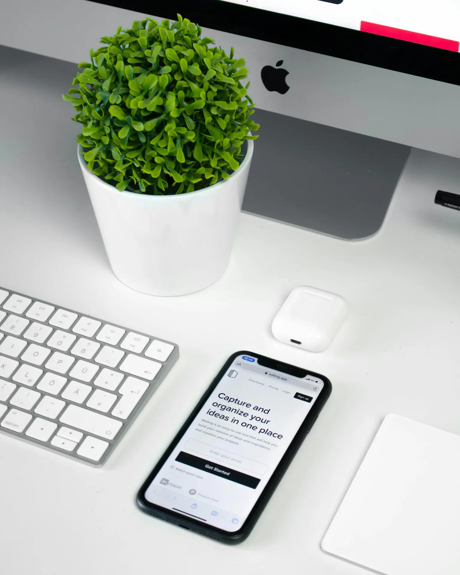 A smartphone displaying a web app on a bright workspace desk